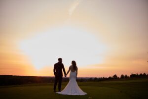 Bride and groom on the course at sunset.