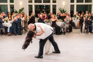 Groom dips the bride on the dancefloor.