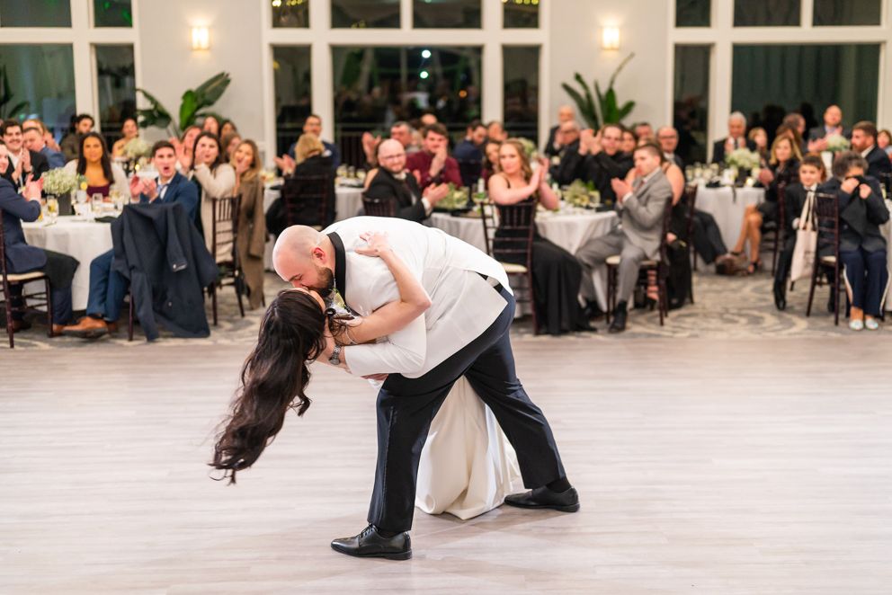 Groom dips the bride on the dancefloor.