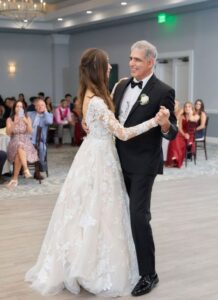 Bride dances with father on the dancefloor.