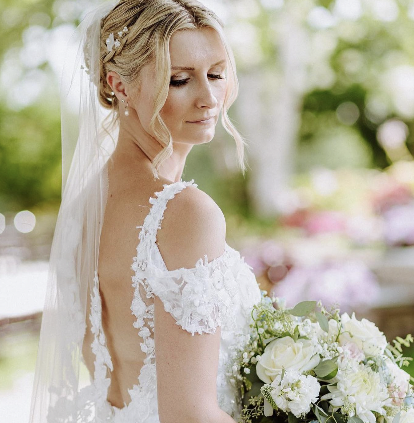 Bride holding white rose bouquet.