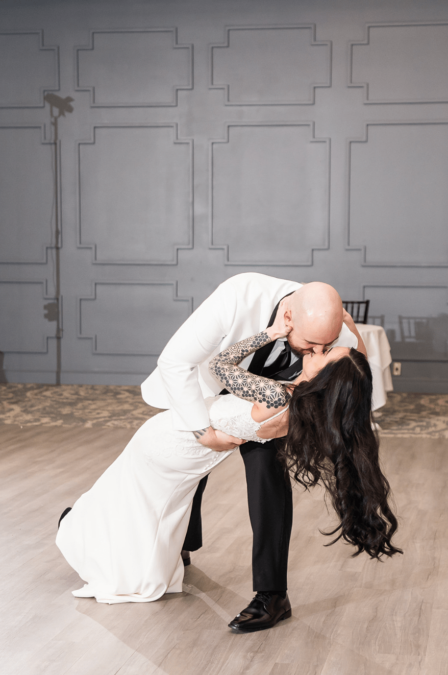 Groom dips the bride on the dancefloor.