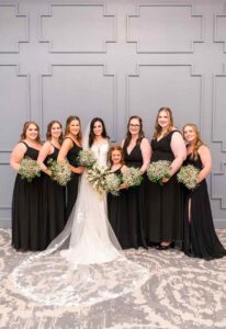 Bride and bridesmaids pose holding bouquets.