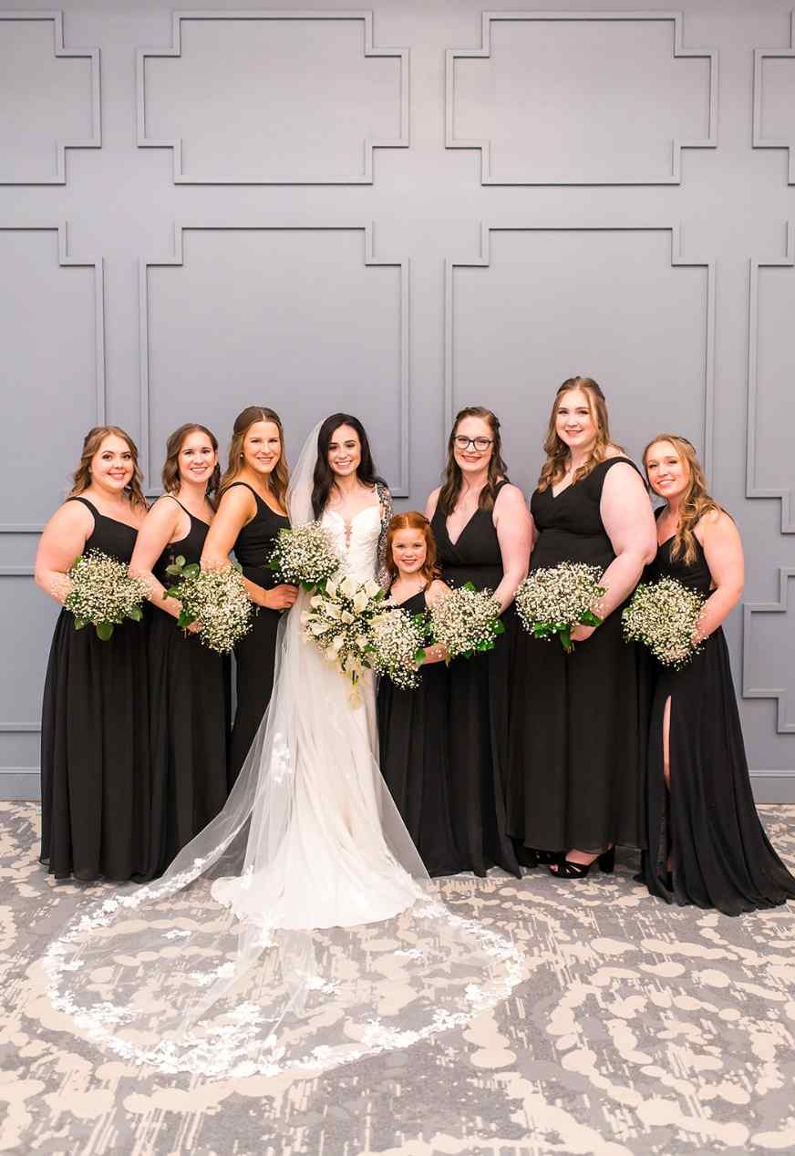 Bride and bridesmaids pose holding bouquets.